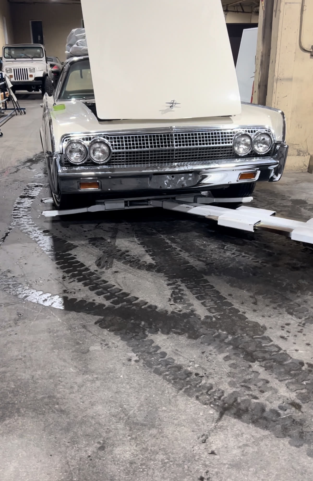 Autowlift arms positioned underneath the front wheels of a parked vehicle