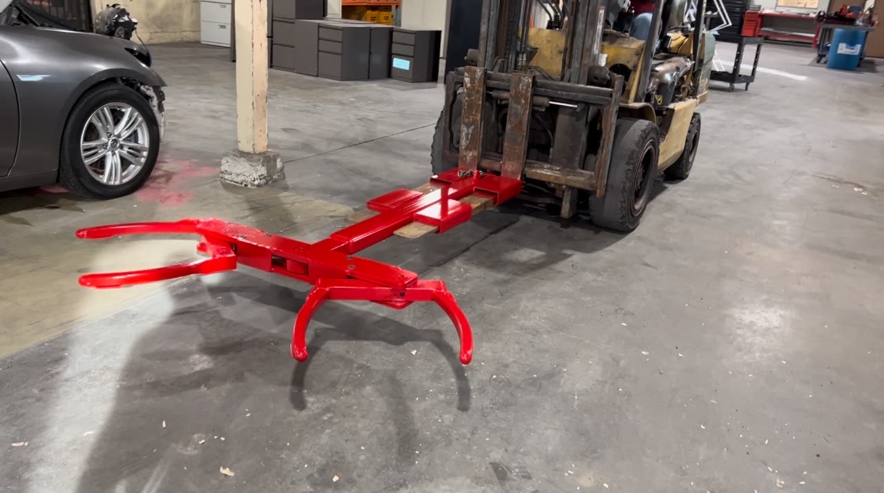 Autowlift attachment mounted on forklift forks in a warehouse