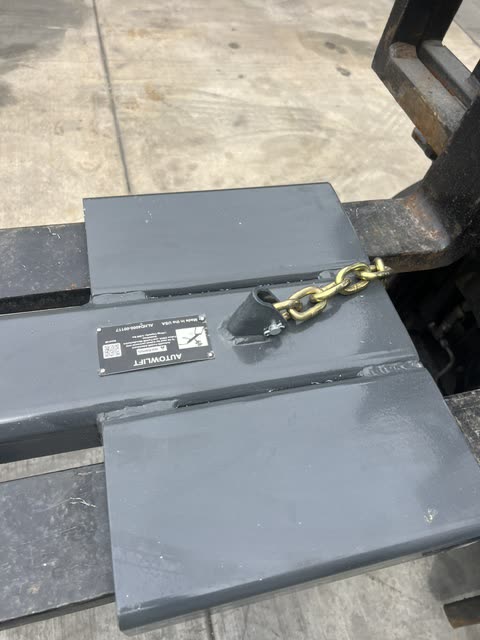 Autowlift mounted on forklift forks with the safety chain hooked in place