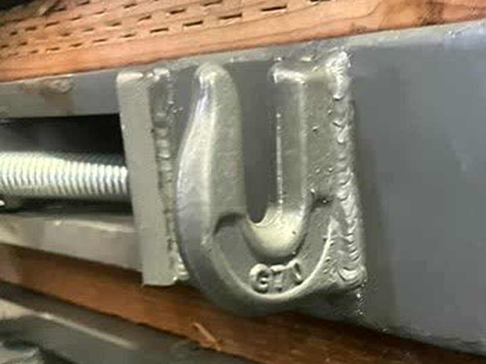 Welded chain hook on the fork pocket of an Autowlift attachment